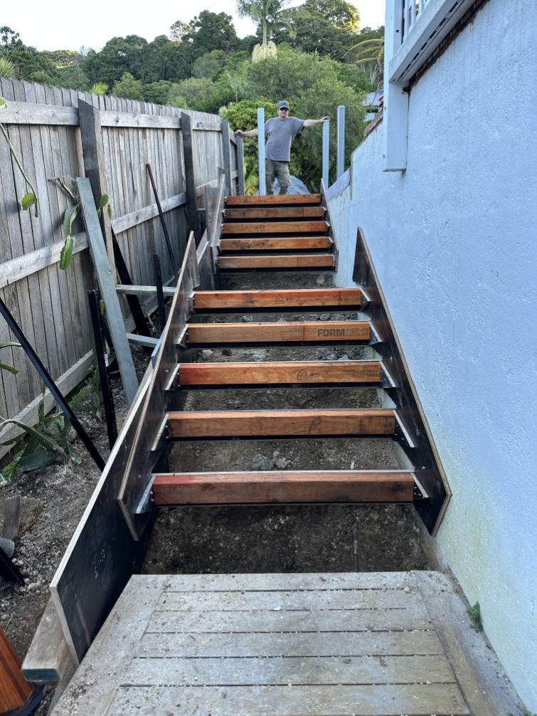 A Man Is Standing On A Set Of Wooden Stairs — Hinterland Concreting Pty Ltd In Lennox Head, NSW