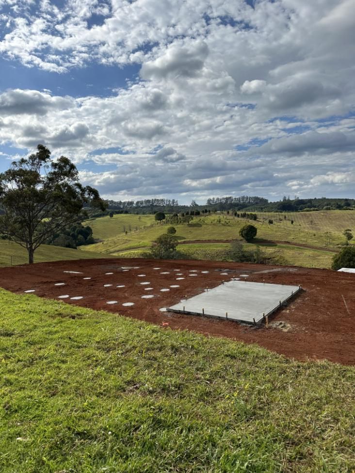 A Large Concrete Slab Is Sitting In The Middle Of A Grassy Field — Hinterland Concreting Pty Ltd In Lennox Head, NSW