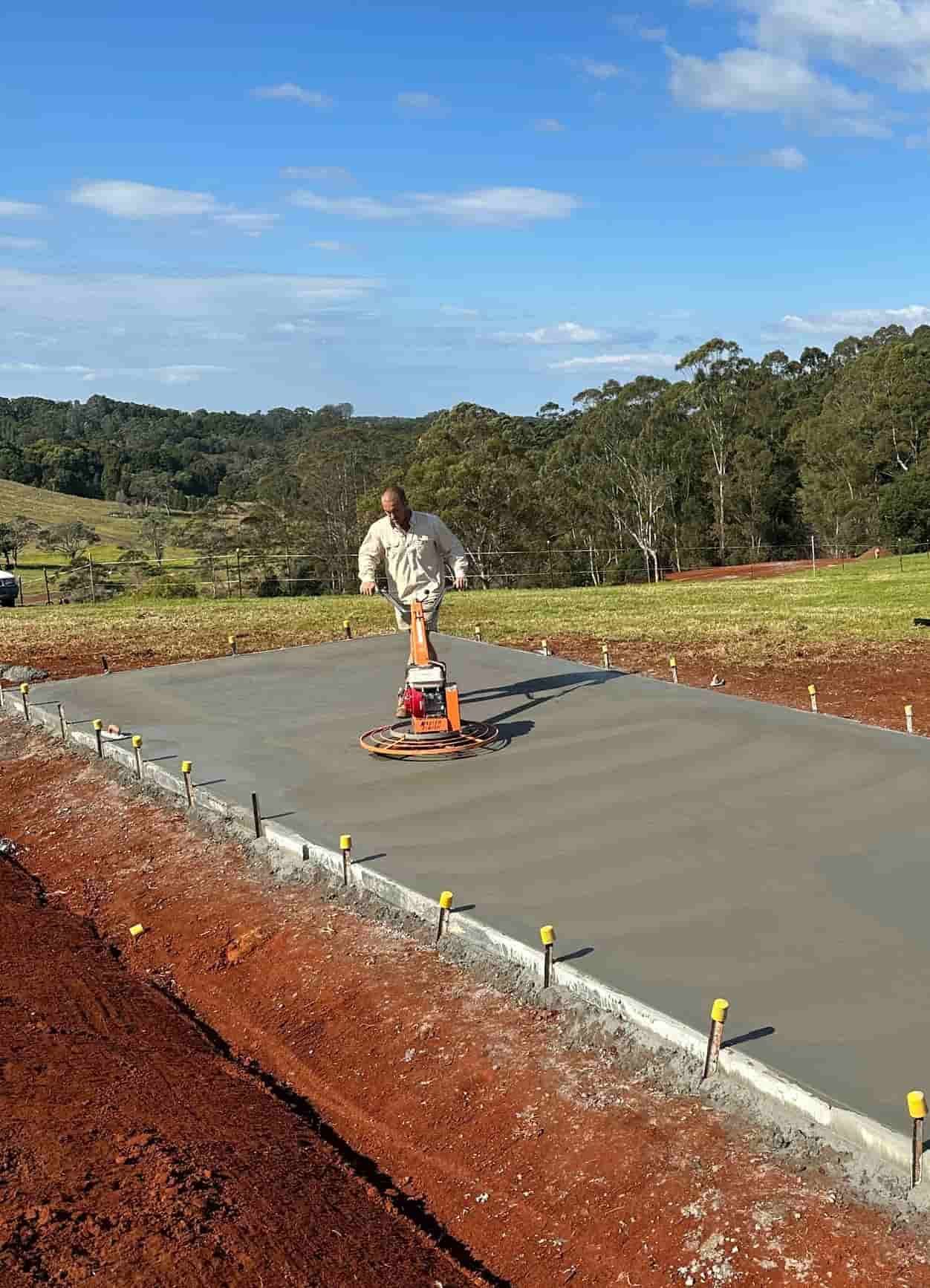 A Man Is Using A Machine To Level A Concrete Surface — Hinterland Concreting Pty Ltd In Lennox Head, NSW