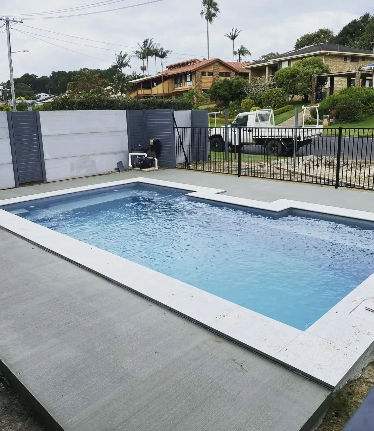 A Large Swimming Pool With A White Truck Parked In The Background — Hinterland Concreting Pty Ltd In Lennox Head, NSW