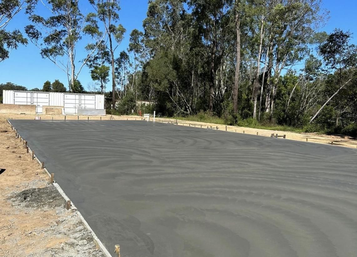 A Concrete Driveway Is Being Built With Trees In The Background — Hinterland Concreting Pty Ltd In Lennox Head, NSW