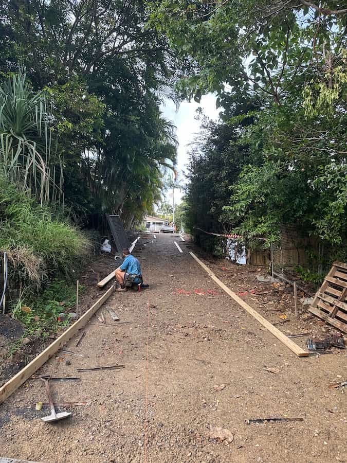 A Man is Sitting on the Side of a Dirt Road — Hinterland Concreting Pty Ltd In Ballina, NSW