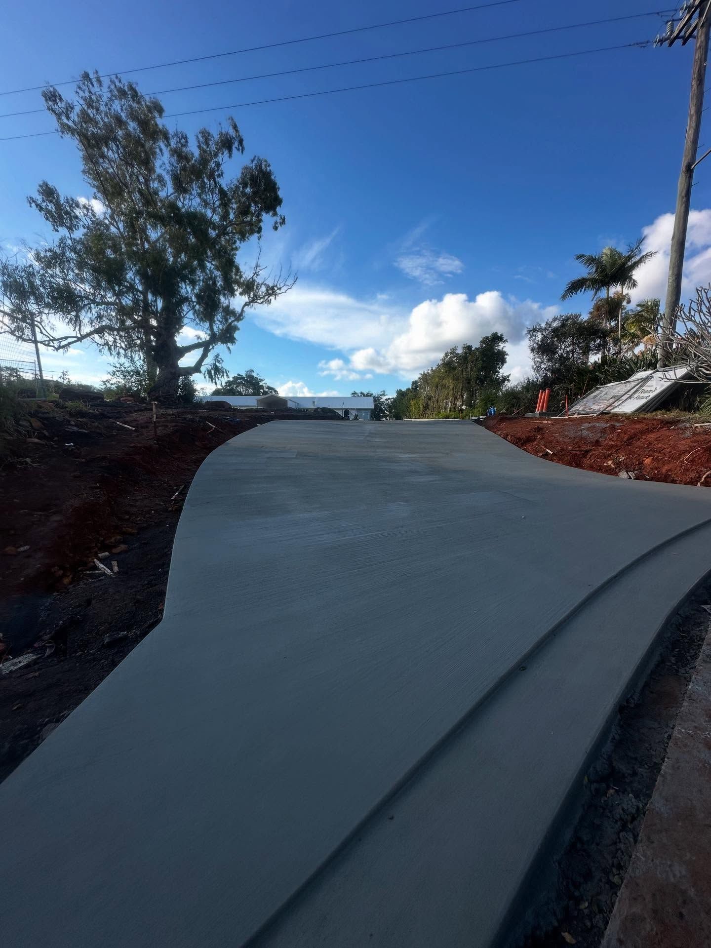 Newly Poured Concrete Driveway Curving Upward on a Sunny Day — Hinterland Concreting Pty Ltd In Lennox Head, NSW