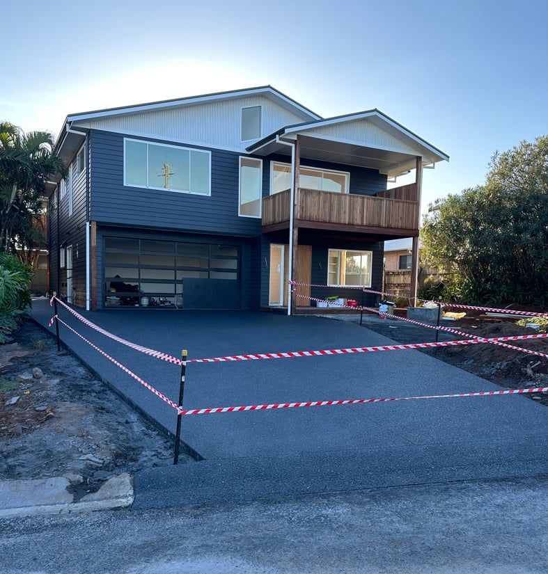 A Large House With A Fence Around The Driveway — Hinterland Concreting Pty Ltd In Lennox Head, NSW