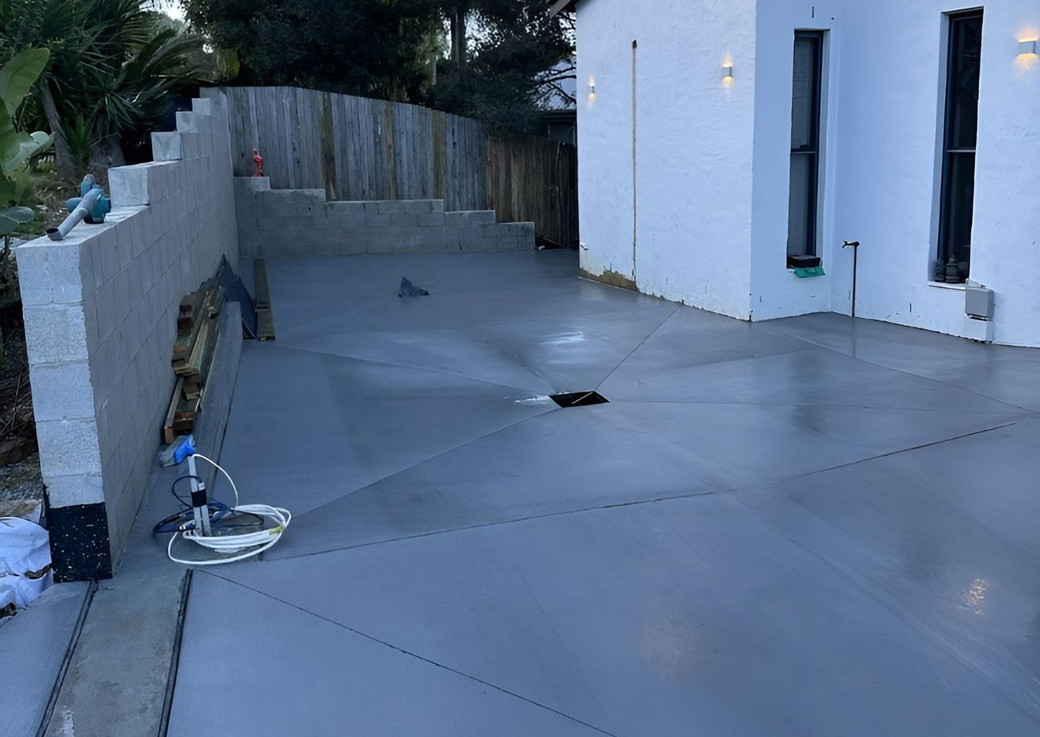 A Newly Poured And Smoothly Finished Concrete Slab Beside A Modern White Home