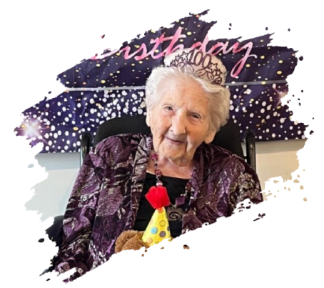 Elderly woman wearing a tiara and party hat, celebrating her 100th birthday.