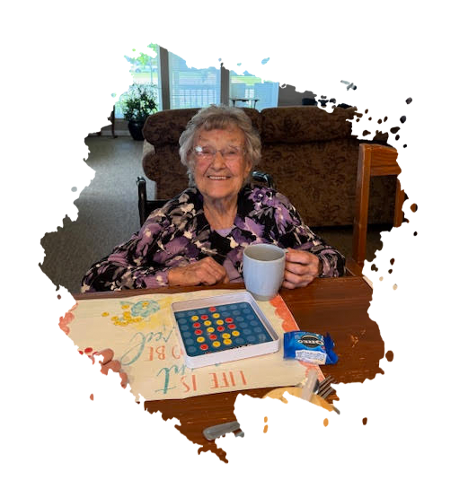 Man in wheelchair talking to a woman, indoors. Man has a beard, hat. Woman smiles, listens.
