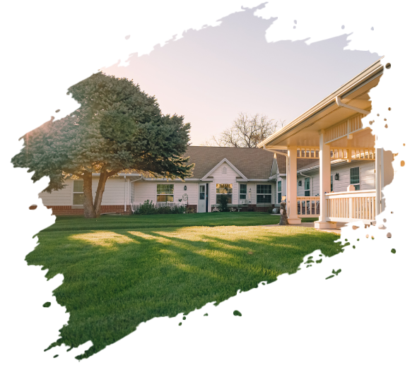 A white building with a gazebo and tree in a grassy yard, bathed in warm sunlight.