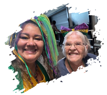 Two women smiling at the camera; one in Mardi Gras attire.