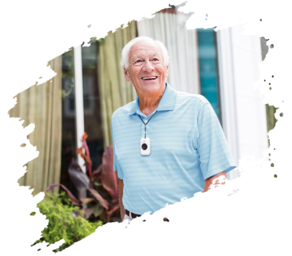 Smiling elderly man wearing a pendant alarm outside a building.