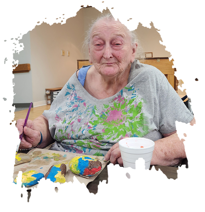 Elderly people in a room with a caregiver, seated and relaxed.