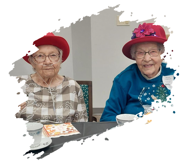 Smiling elderly man in blue shirt gives double thumbs-up outdoors on a path.