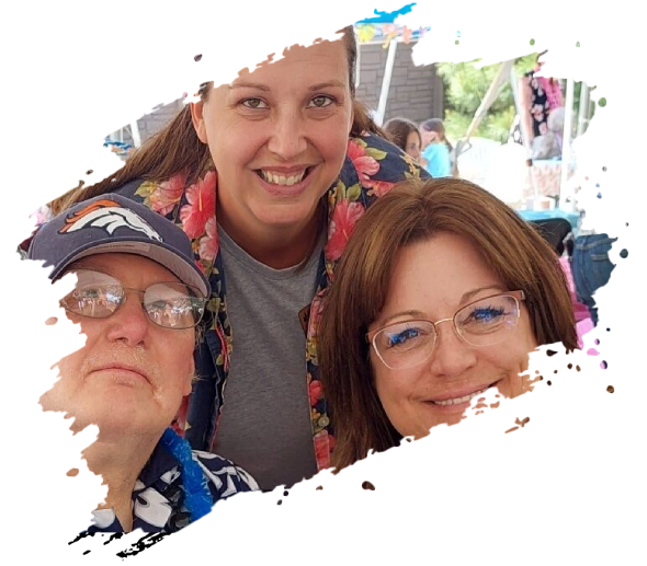 Three people smiling, one wearing a Broncos hat. Outdoor setting, colorful clothes.