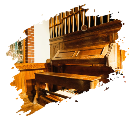 Wooden church organ with visible pipes, keys, and bench.