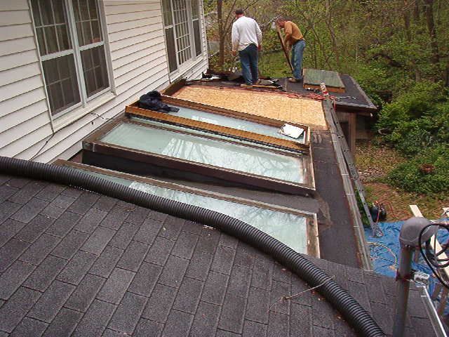 Two Men Are Working on The Roof of A House — Columbia, MO — Naugle Construction Company