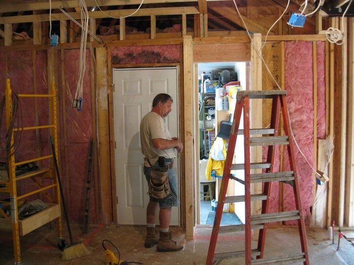 Man Standing in A Room with A Ladder in Front of Him — Columbia, MO — Naugle Construction Company