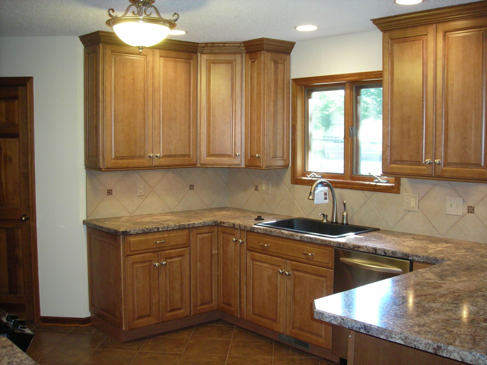A Kitchen with Wooden Cabinets and Granite Counter Tops — Columbia, MO — Naugle Construction Company