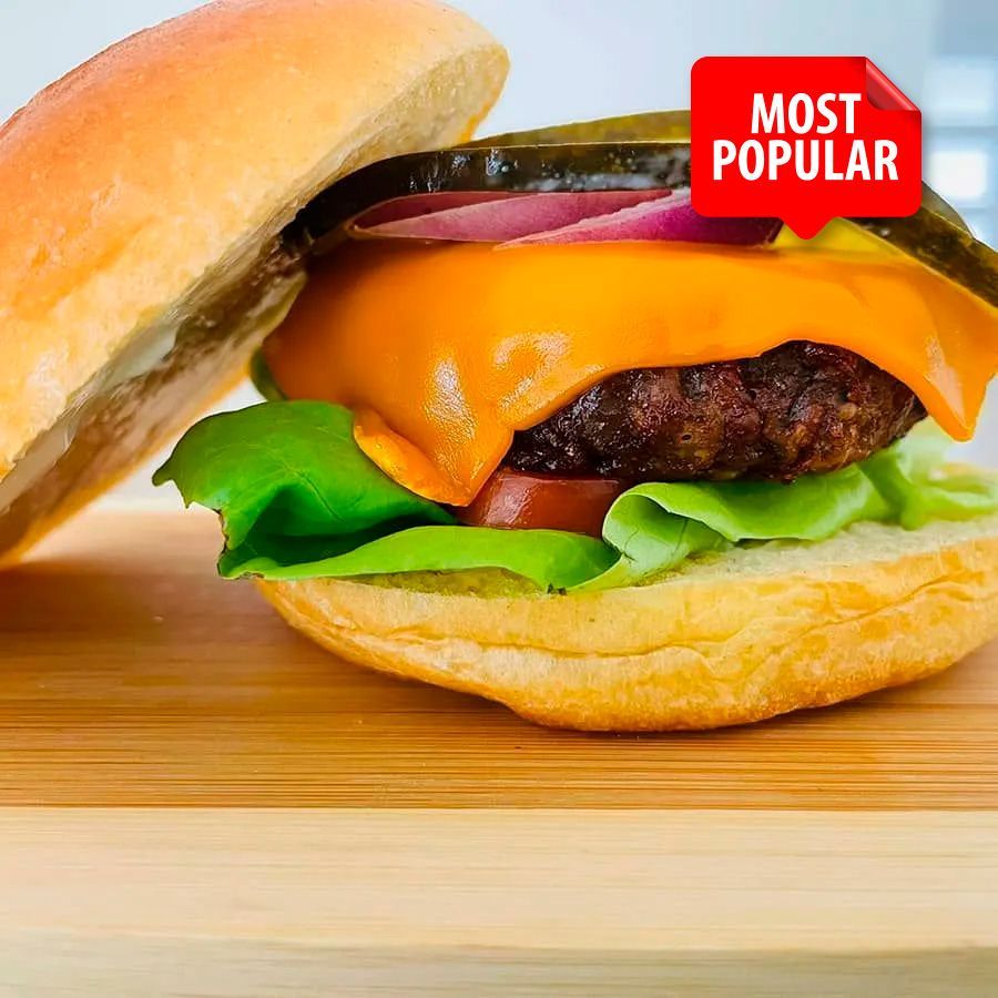 A most popular hamburger is sitting on a wooden cutting board