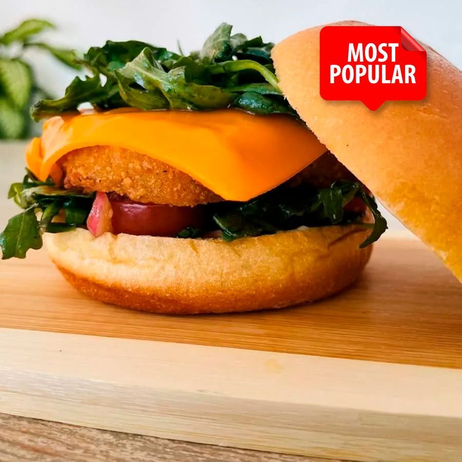 A most popular sandwich is cut in half on a wooden cutting board