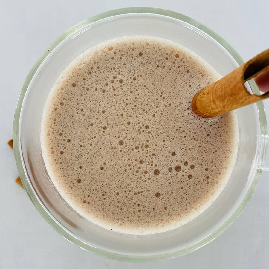 A glass of milk with a cinnamon stick in it
