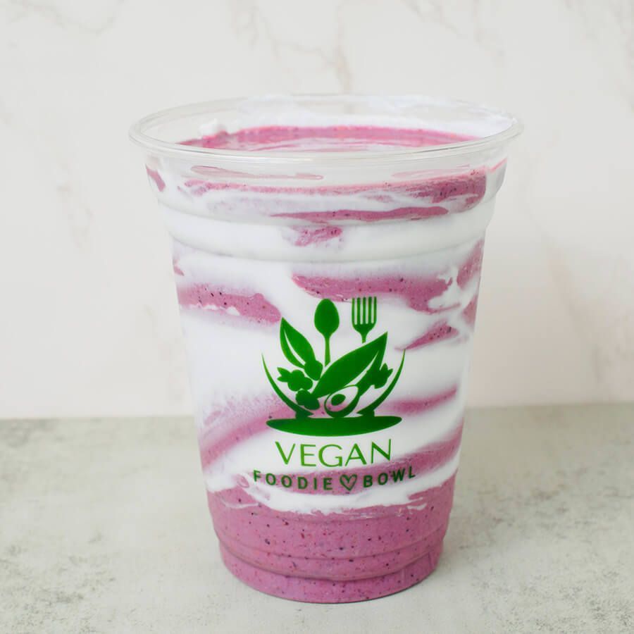 A milkshake in a plastic cup with a red and white striped straw
