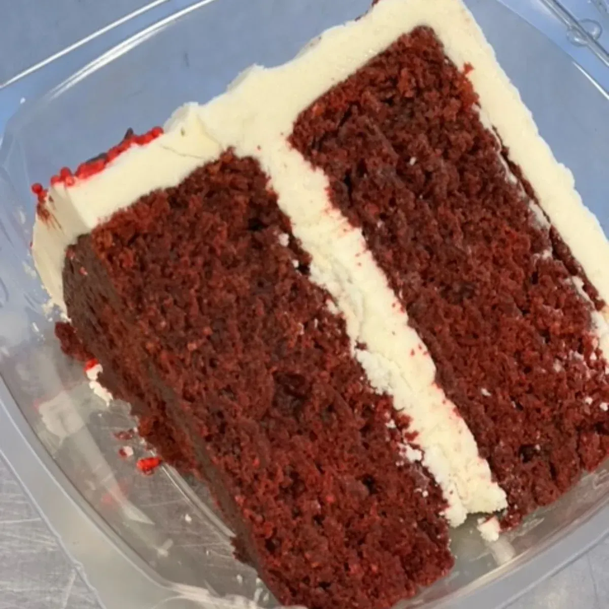 A slice of red velvet cake in a plastic container