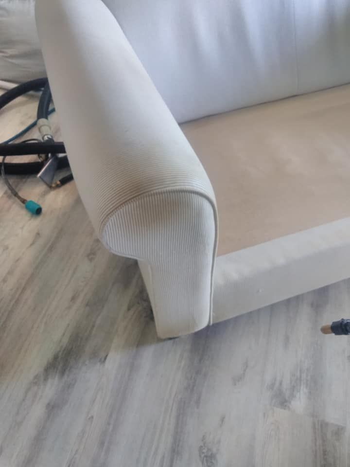 Beige armchair on a light wood floor, with cables visible behind it.