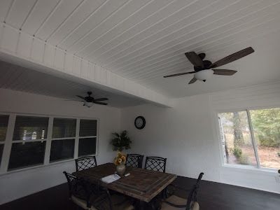 A dining room with a table and chairs and a ceiling fan.