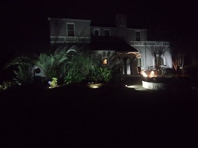 A large white house is lit up at night.