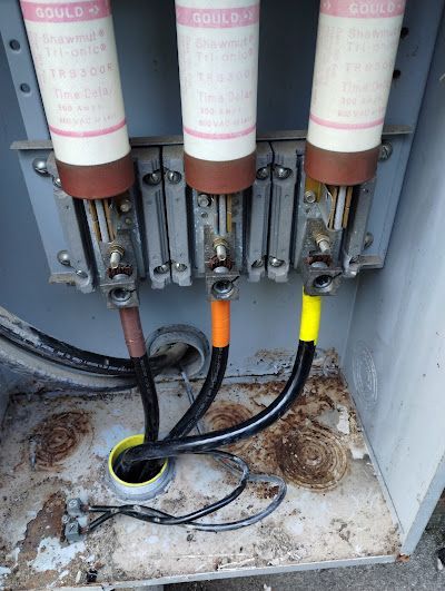 A close up of a electrical box with a bunch of wires coming out of it.