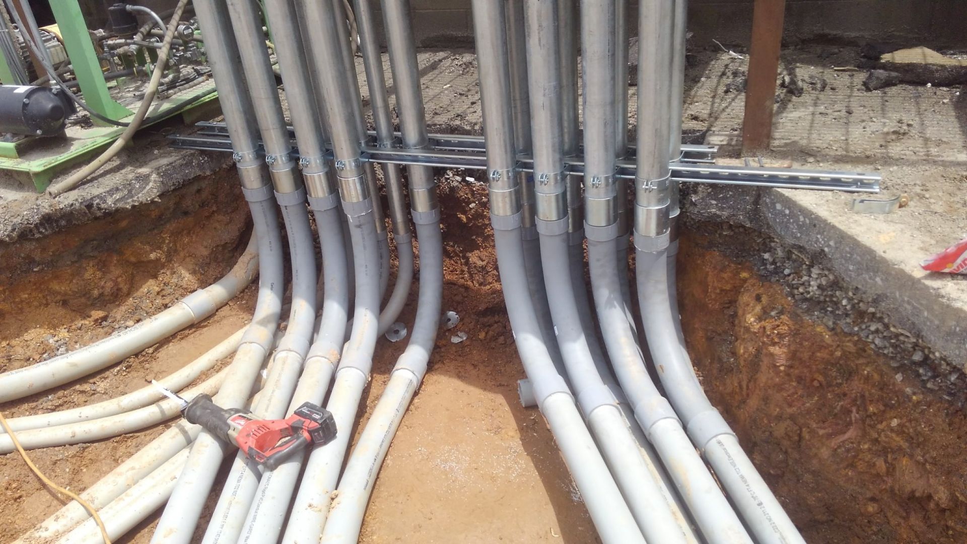 A bunch of electrical wires are laying in the dirt.