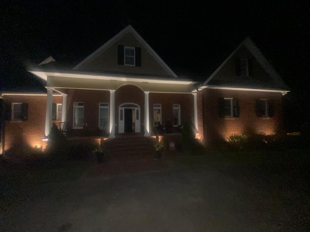 A large brick house is lit up at night.