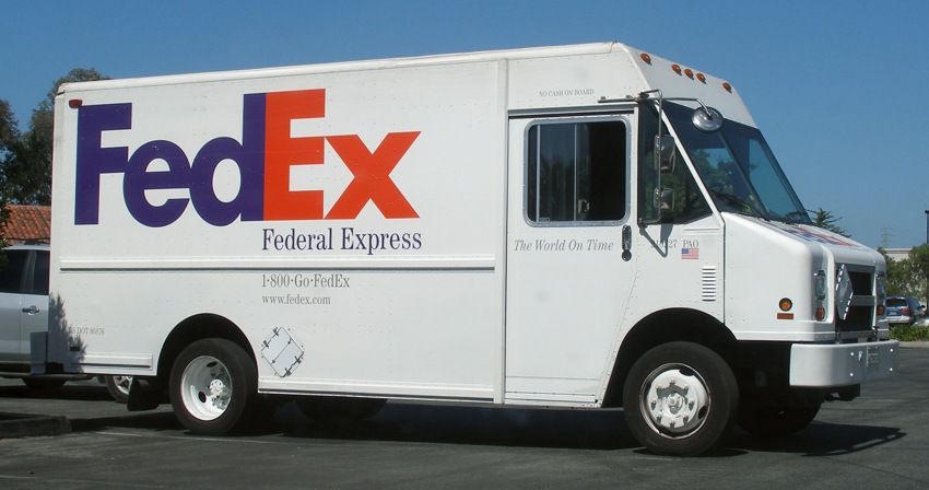 A fedex truck is parked in a parking lot