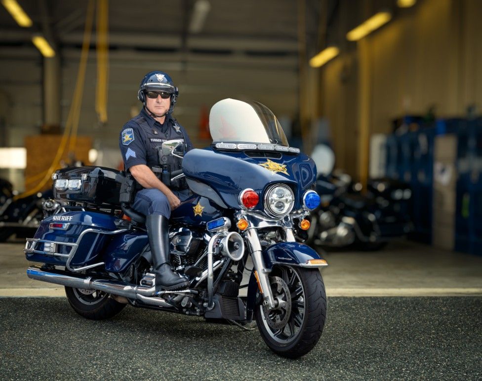 A police officer is riding a motorcycle in a garage.
