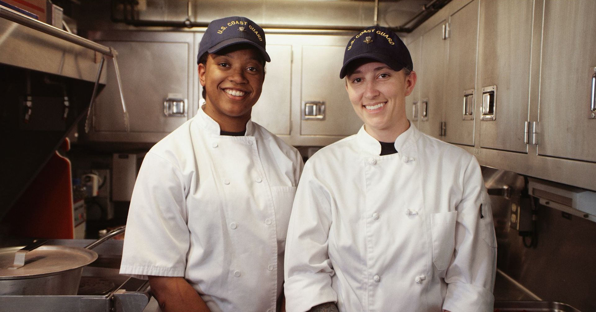 Two chefs standing next to each other in a kitchen