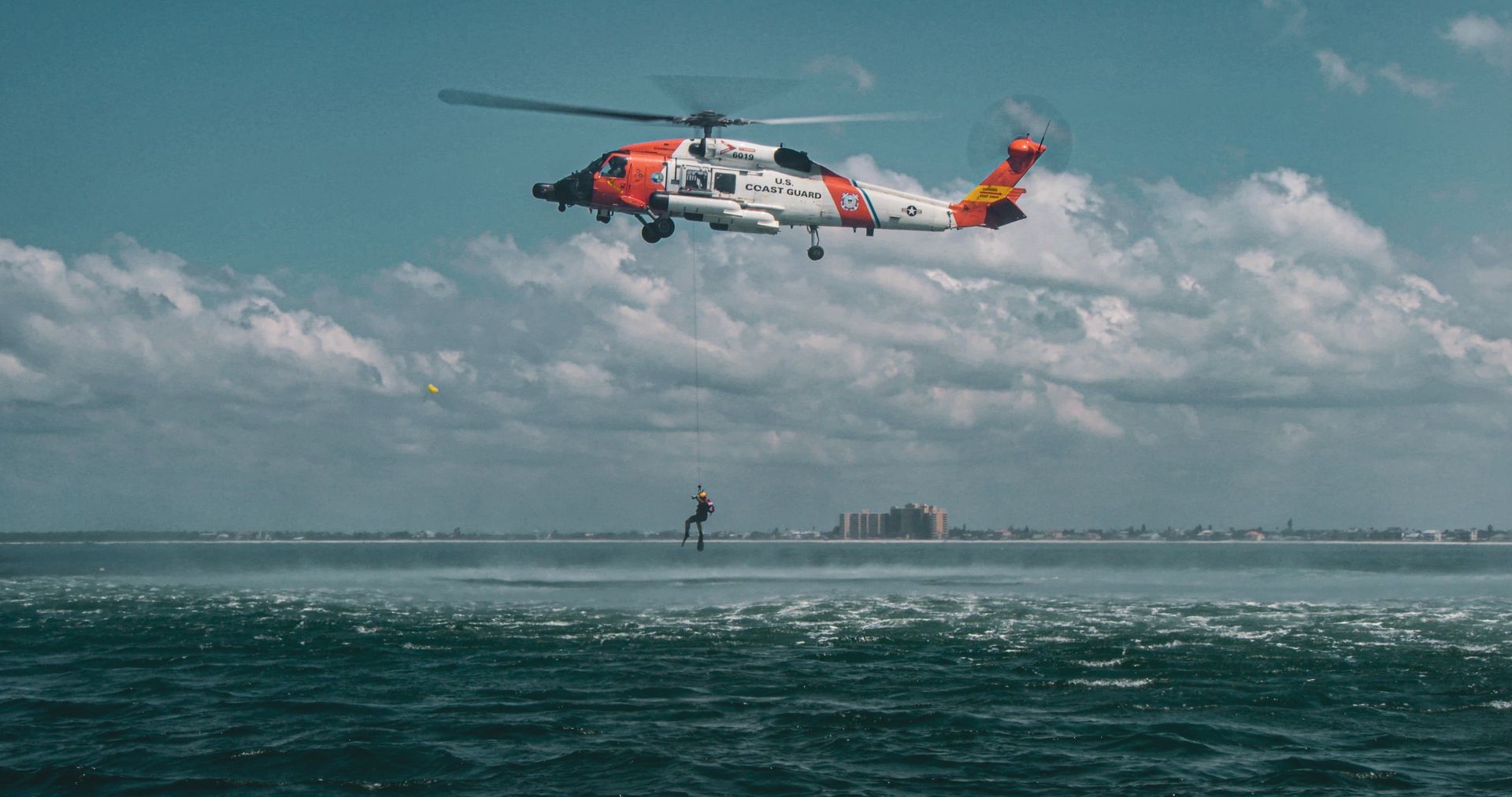 A helicopter is flying over a body of water.