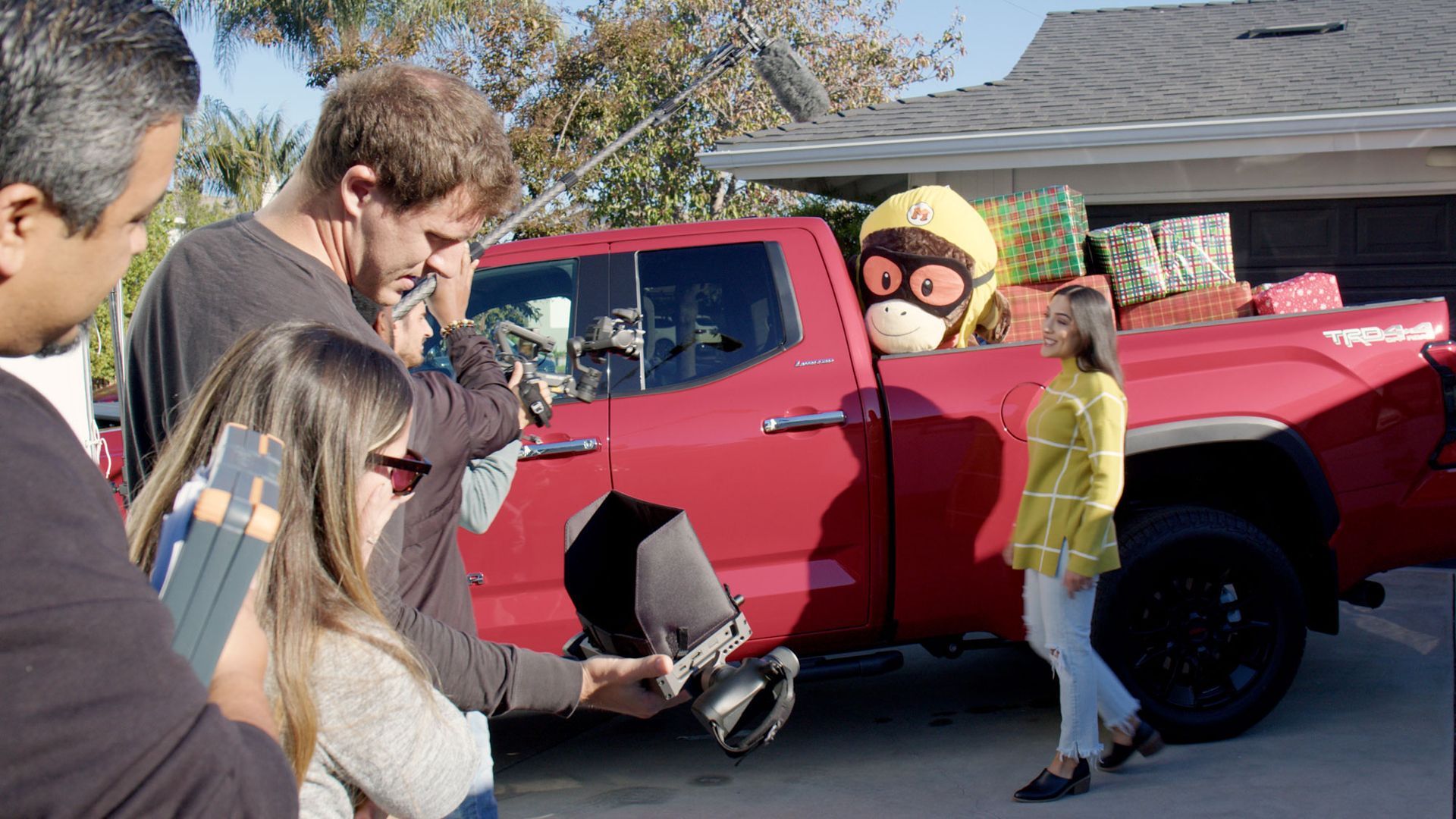 A group of people are standing around a red truck.