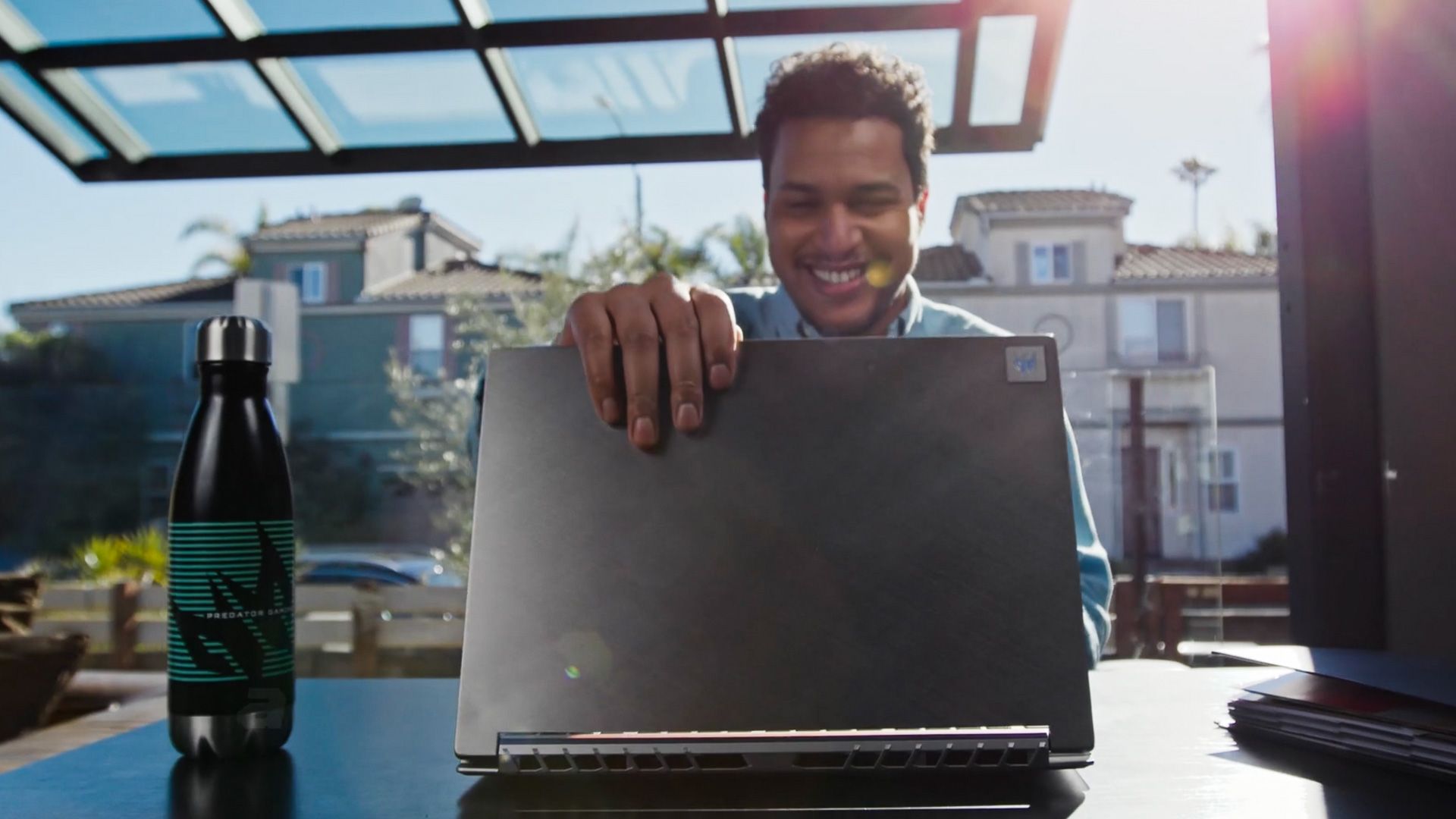 A man is sitting at a desk holding a laptop computer.