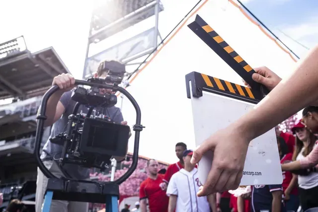 A person is holding a clapper board in front of a camera