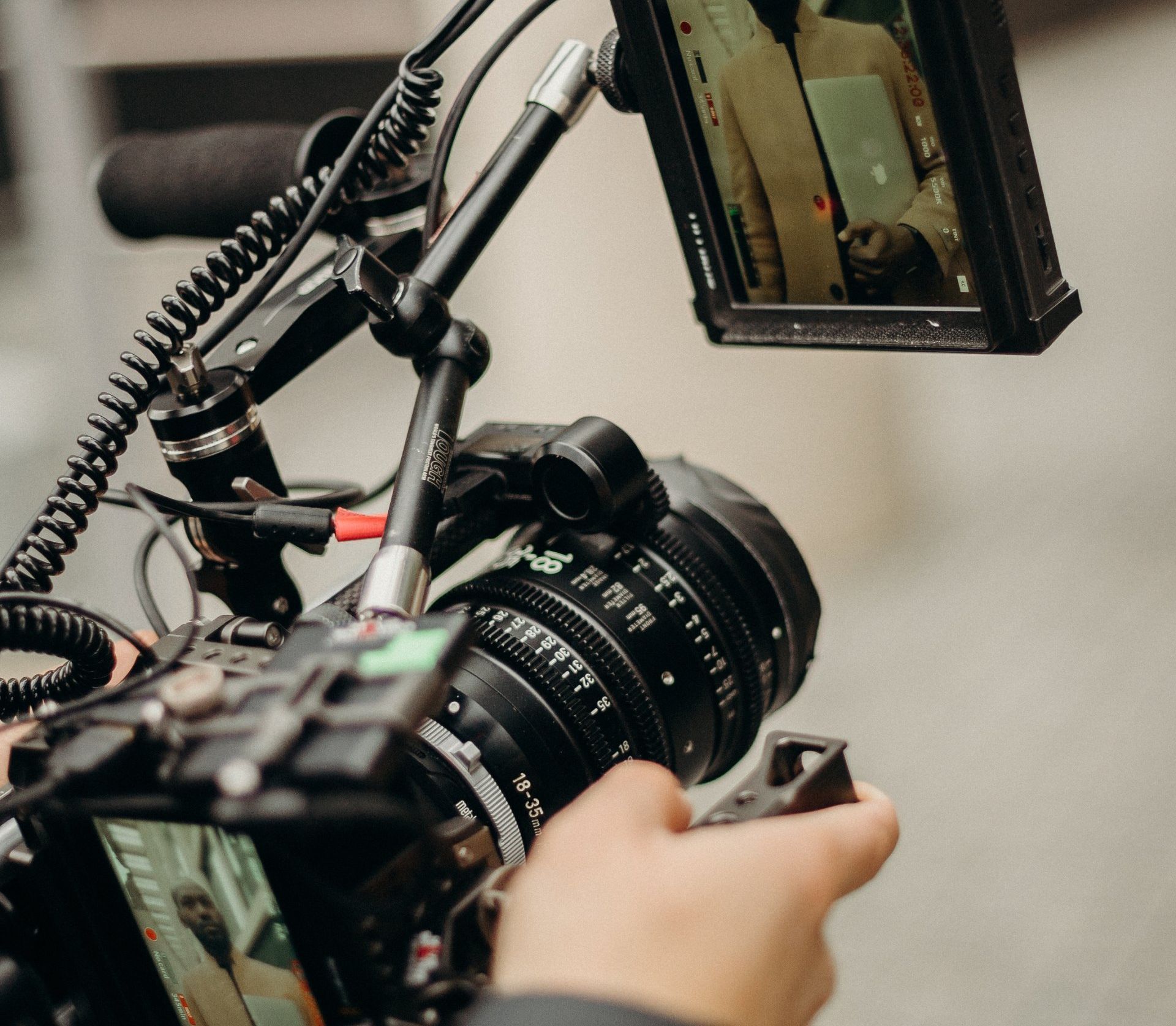 A person is holding a camera with a screen attached to it.