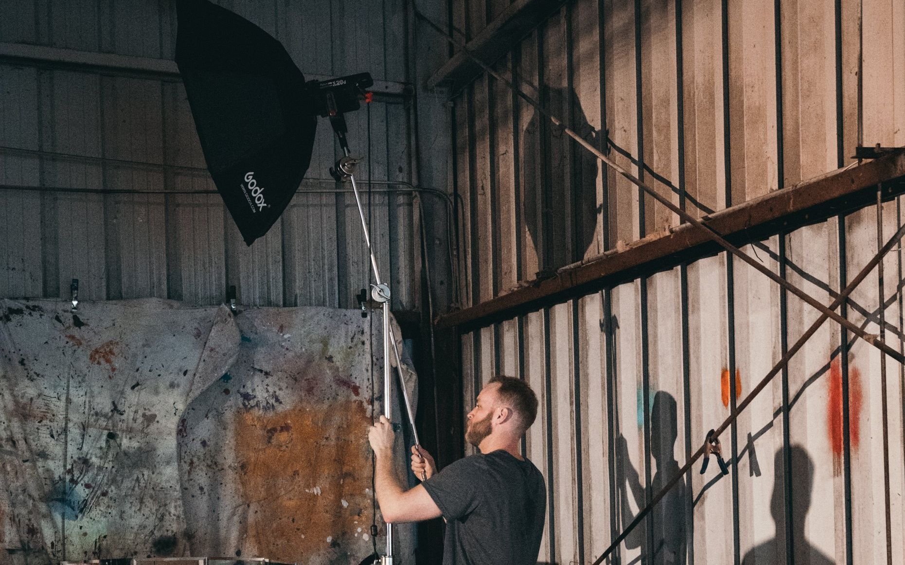 A man is standing in a warehouse holding a light.