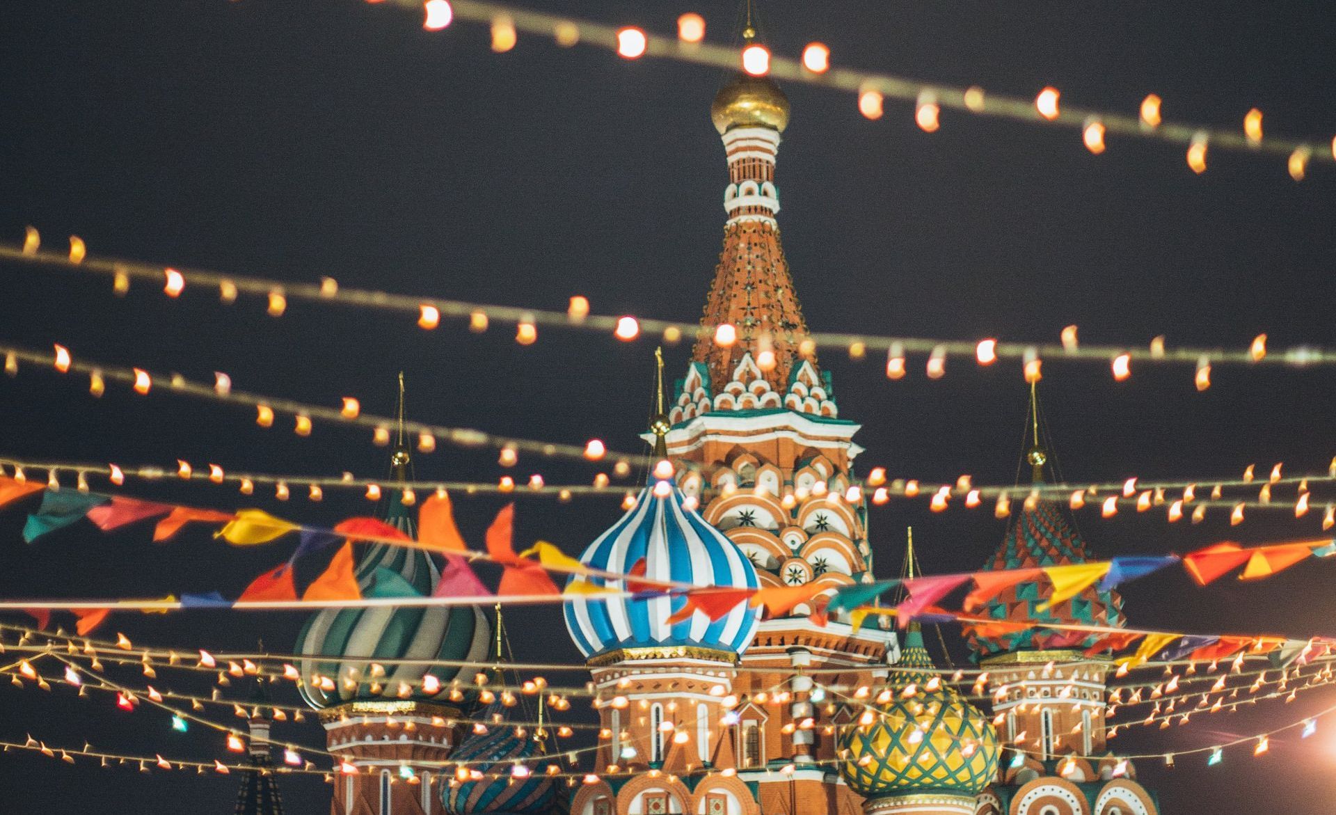 A church is decorated with flags and lights at night.