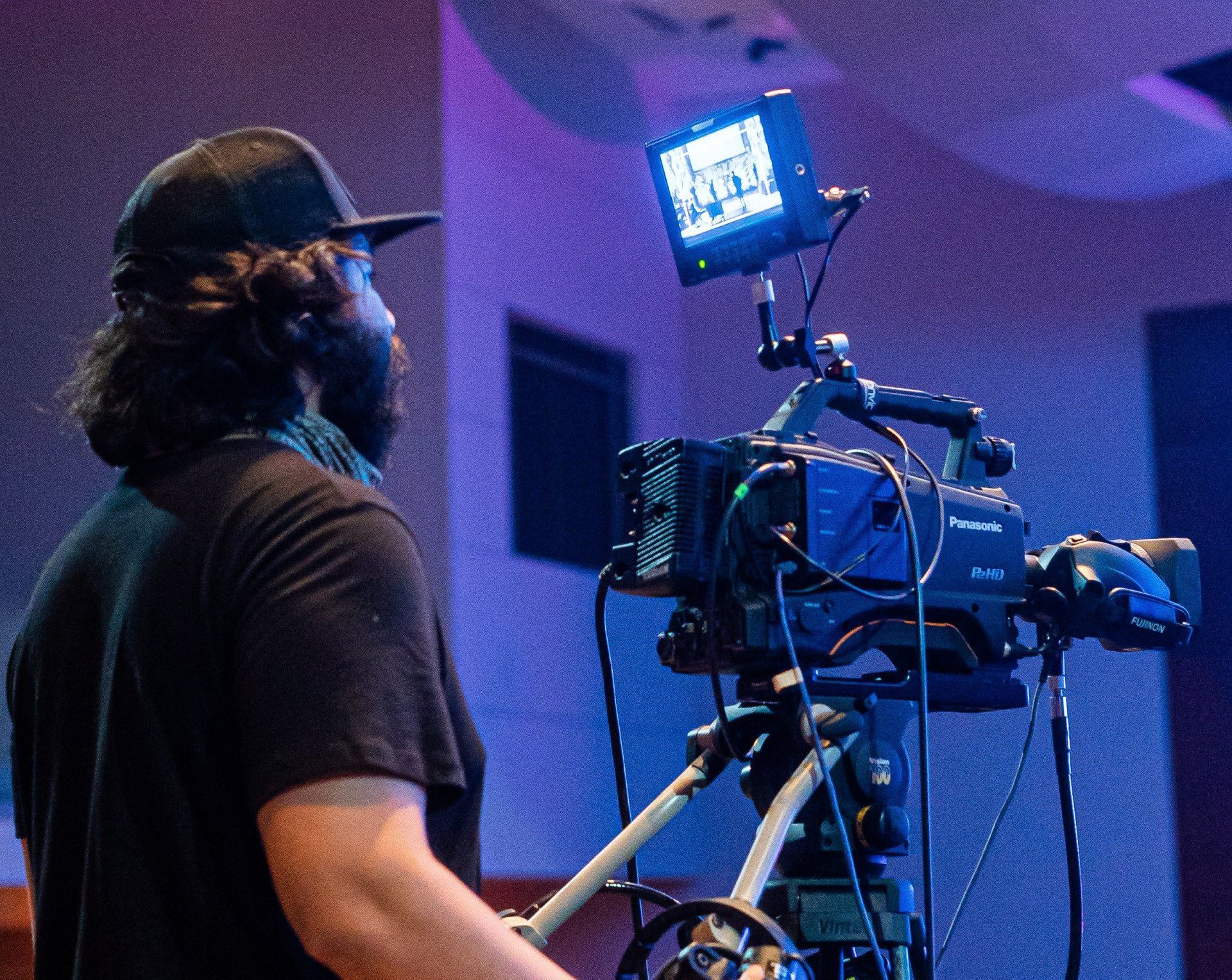 A man stands in front of a camera that says ' panasonic ' on it