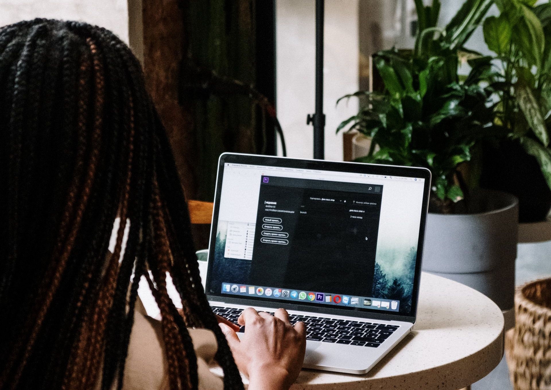 A woman is sitting at a table using a laptop computer.