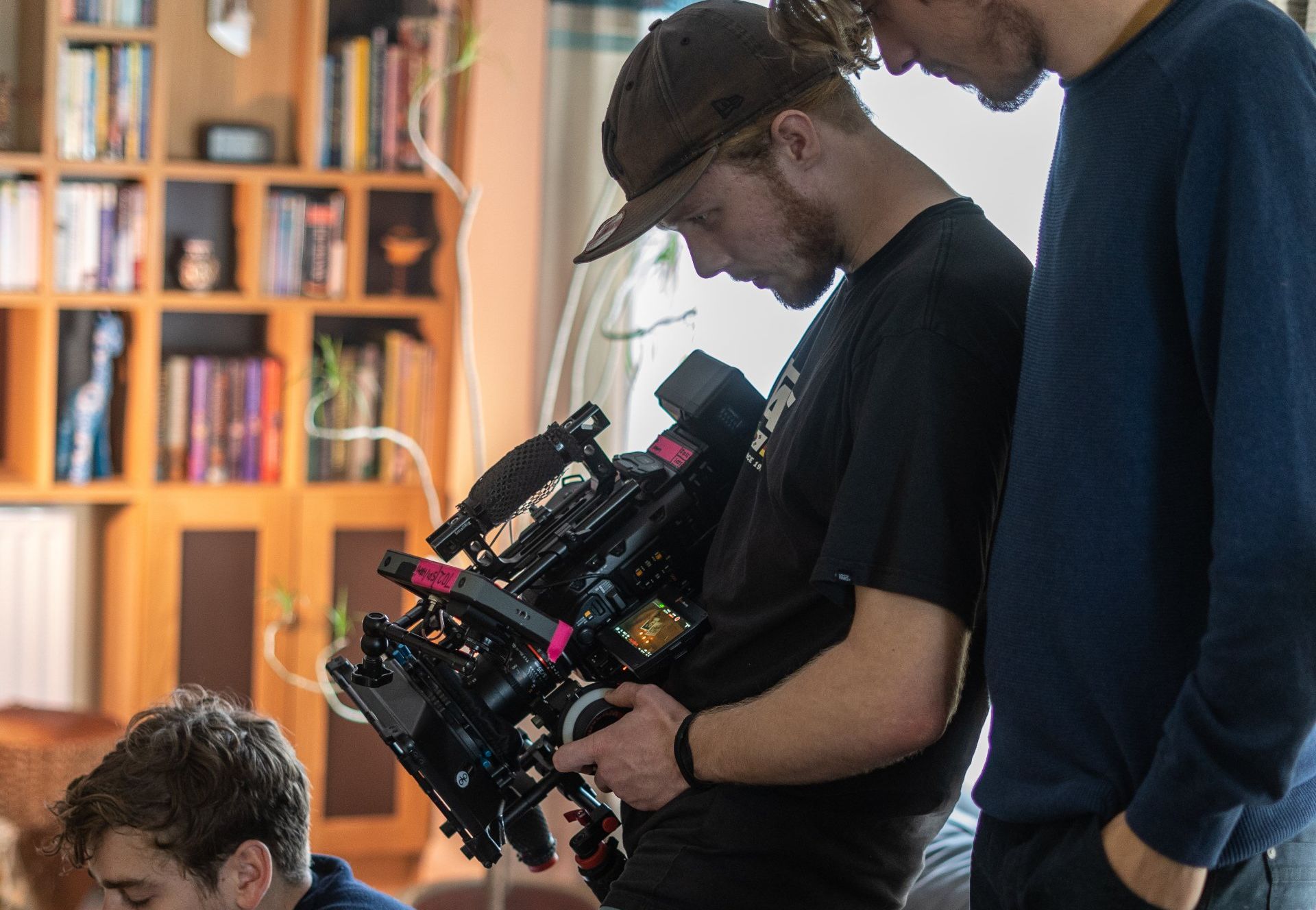 Two men are looking at a camera in a living room.