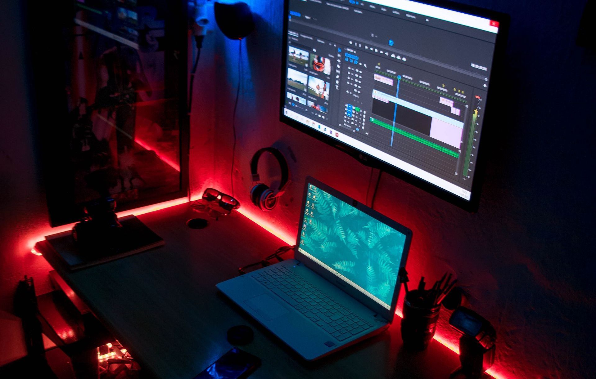 A laptop computer is sitting on a desk next to a monitor.