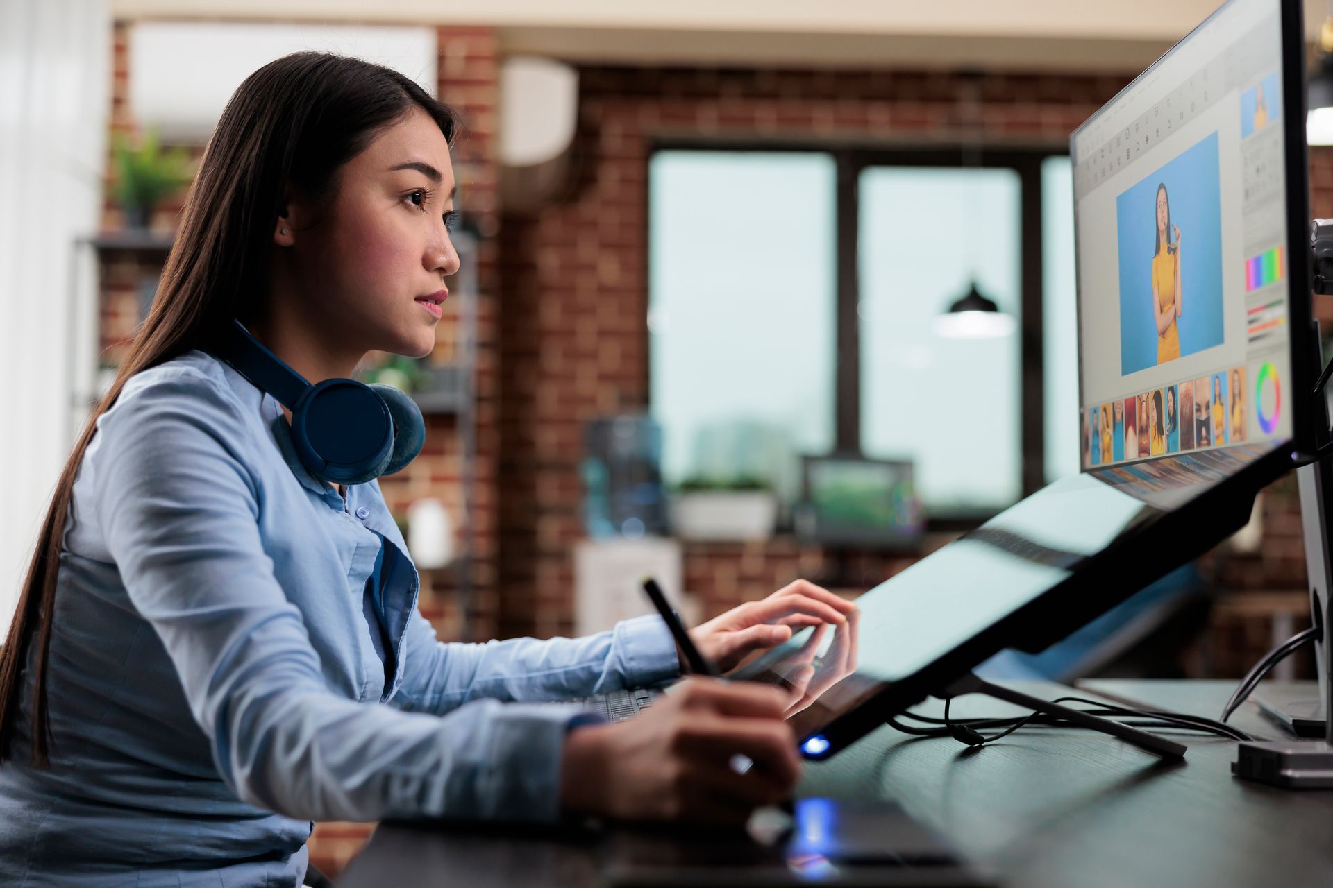 A woman is sitting at a desk working on a computer.