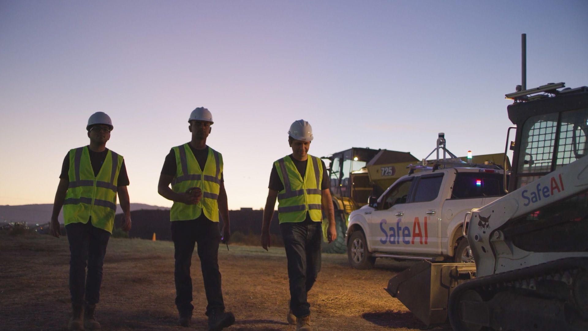 A group of construction workers are walking down a dirt road.