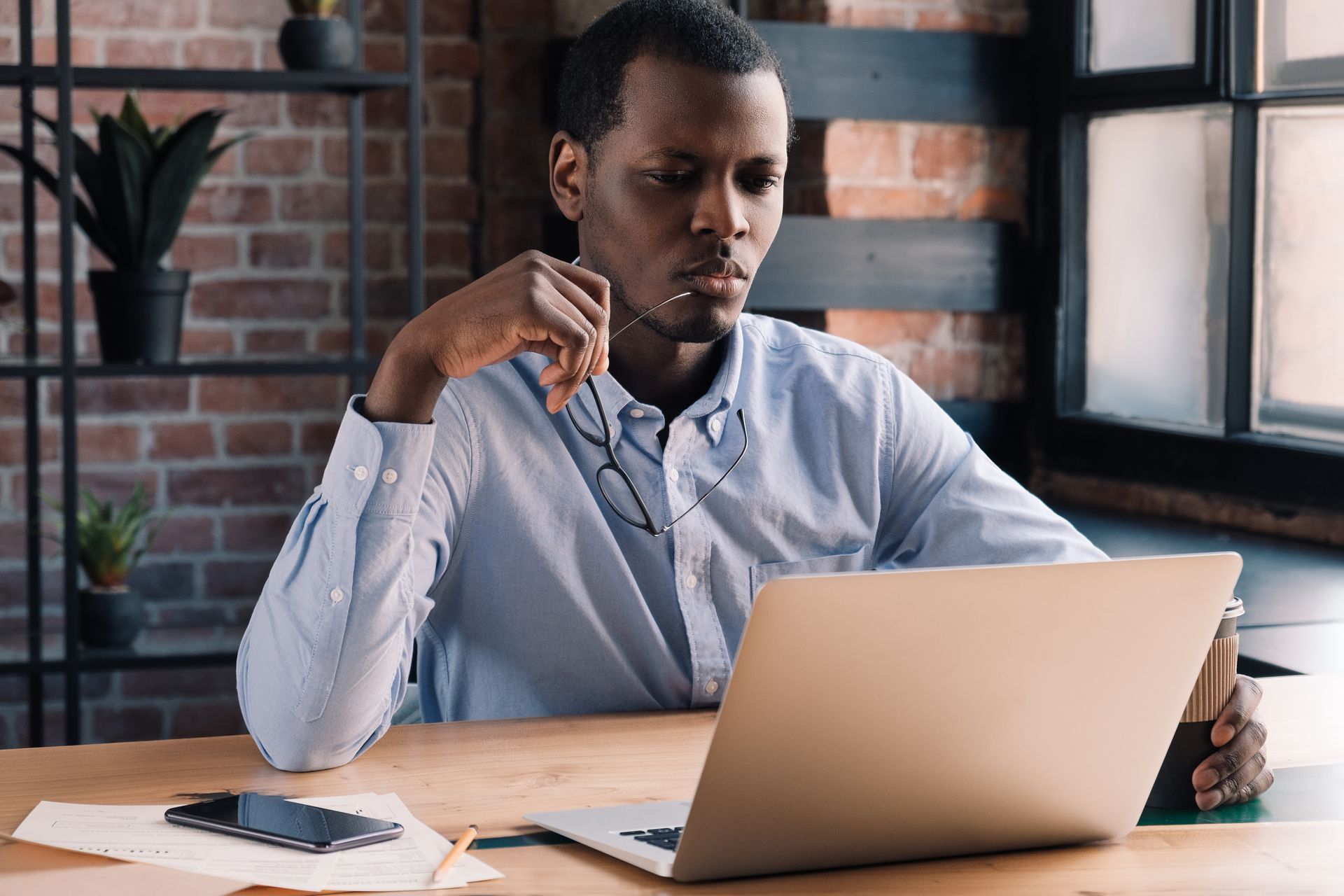 A man is sitting at a desk using a laptop computer.