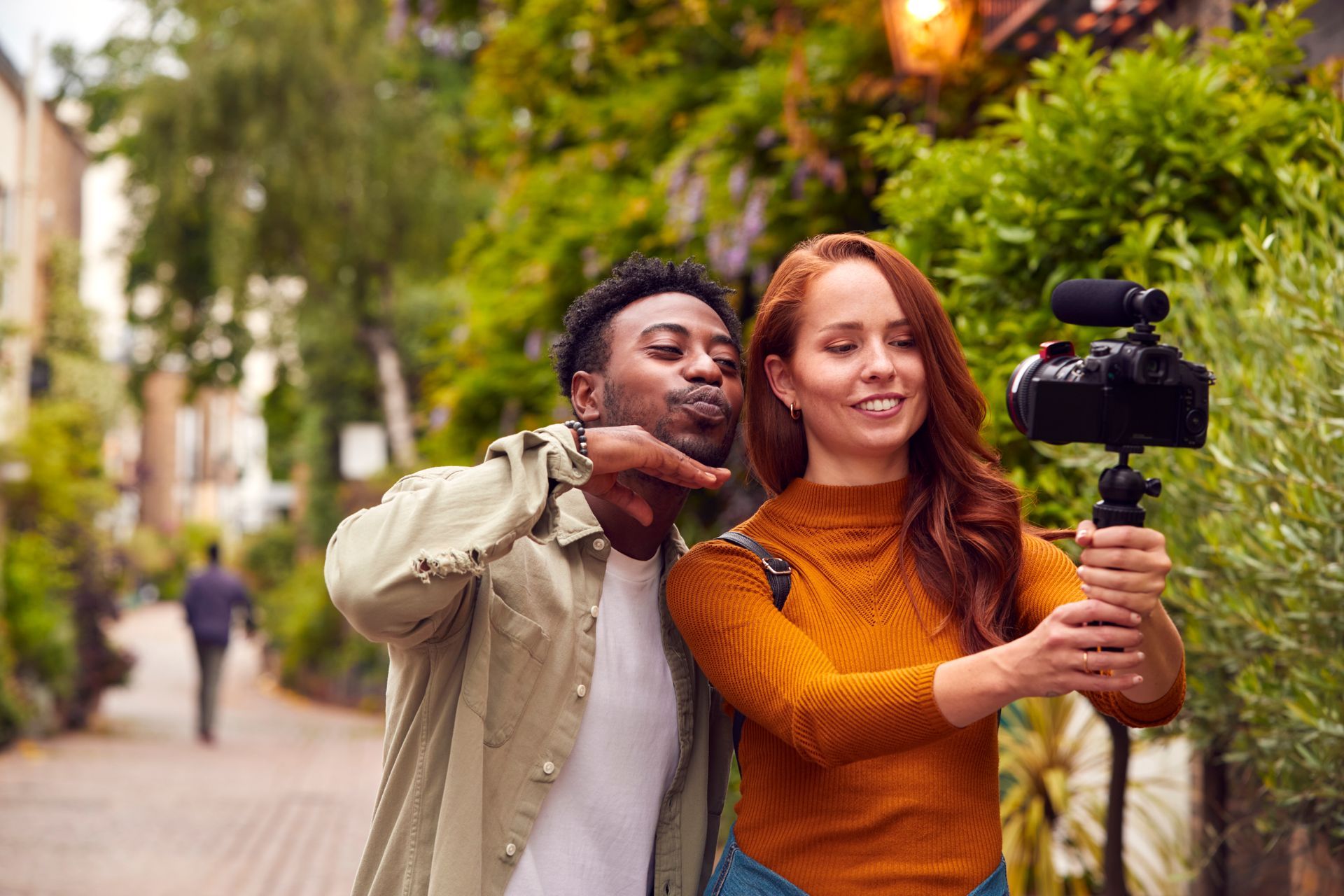 A man and a woman are taking a selfie with a camera.